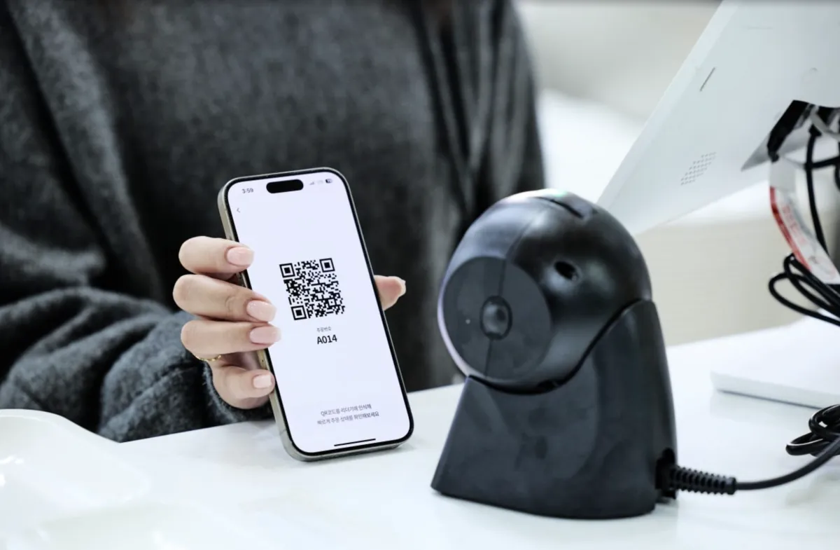 앱의 QR 코드를 매장 리더기에 인식하는 모습